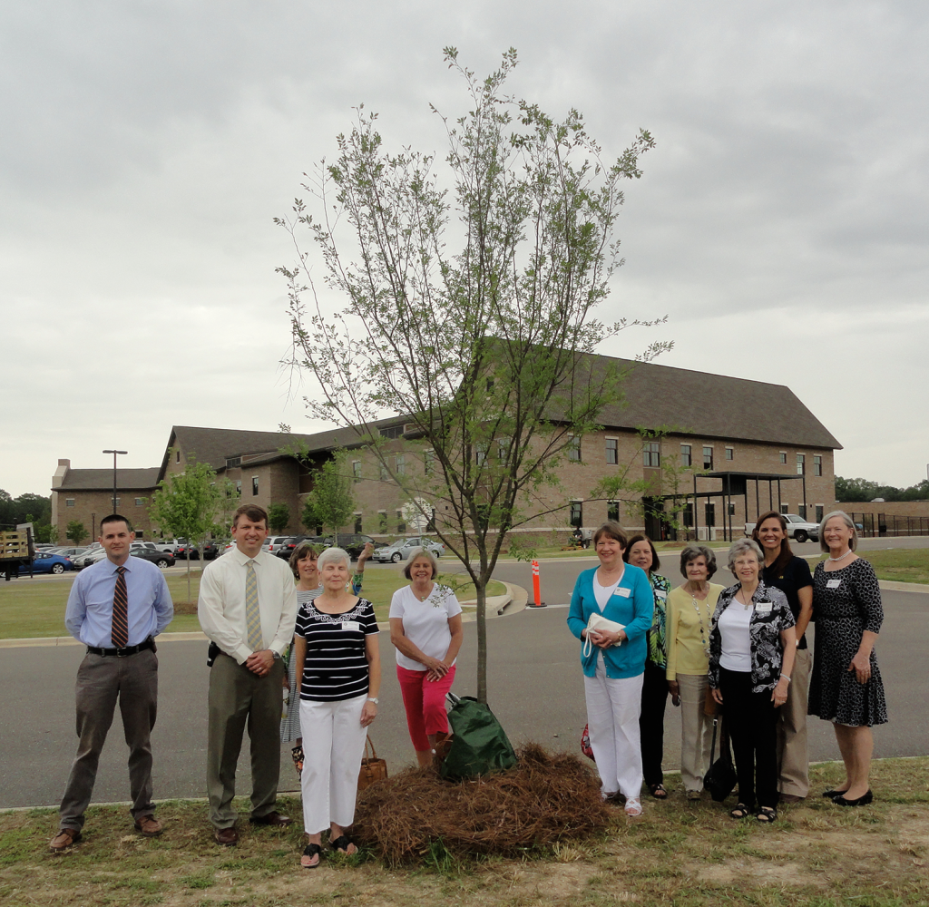 Montgomery Trees Trees For Schools delegation next to a previously planted tree at Park Crossing High.